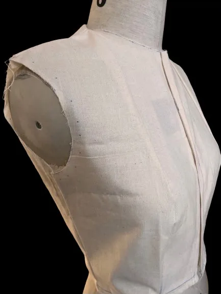 Side view of the calico bodice on the dress form, showing the armhole and side seam.