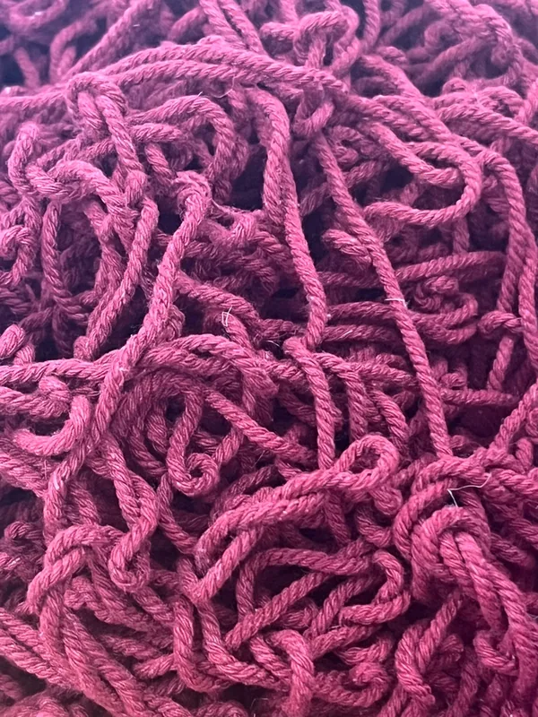 Close-up of tangled magenta yarn.